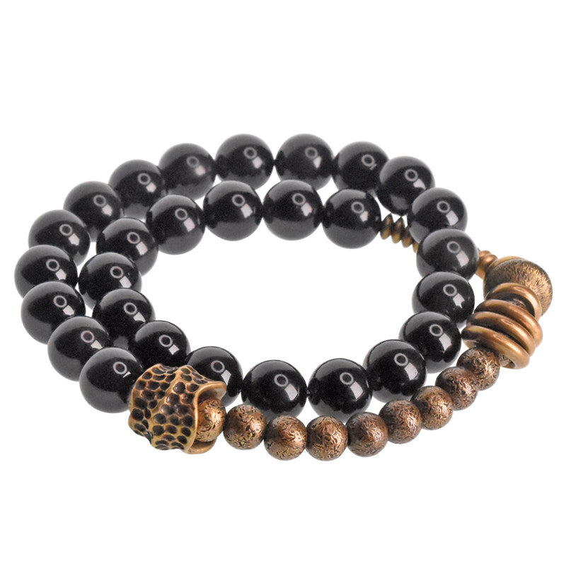 Front view of Serene Lucky's Tectonic Force wrap bracelet with obsidian beads and irregular molten-textured brass.
