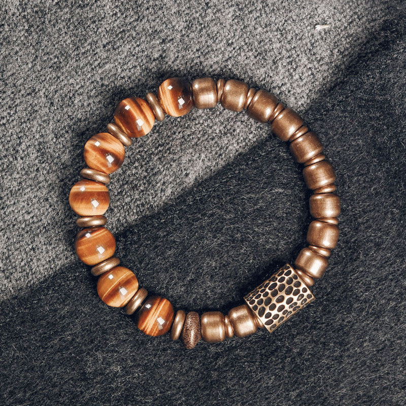 Handcrafted Serene Lucky bracelet featuring natural Tiger's Eye gemstones with a unique cat-eye glow, paired with rustic hammered brass beads for a vintage, grounded look.