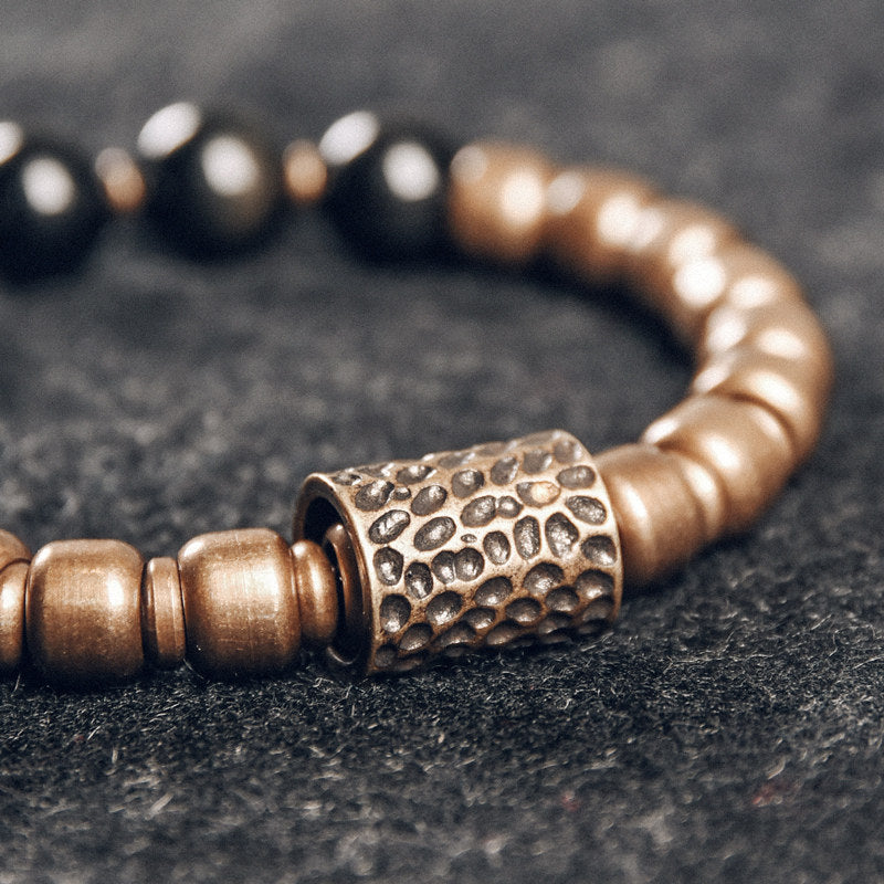 Detailed view of hand-finished, hammered brass beads, emphasizing the artisan texture and rustic charm of the jewelry.