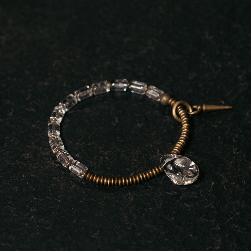 Angled view of a handcrafted single-strand bracelet showcasing the contrast between raw crystal and metal.