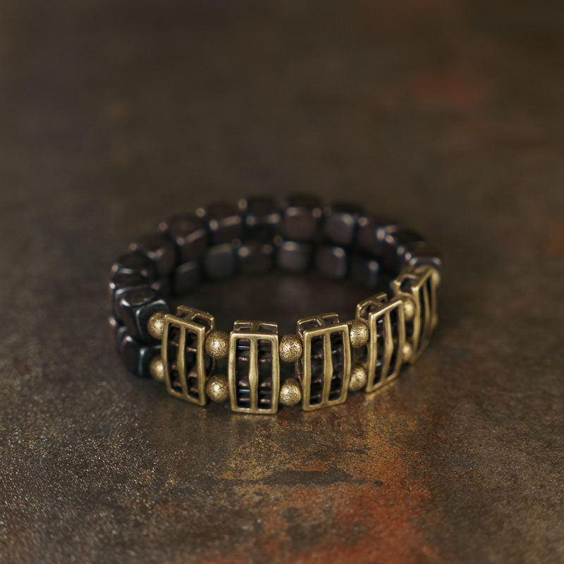 Close-up of the smooth, dark grain of natural Ebony wood slabs on the Serene Lucky architectural bracelet