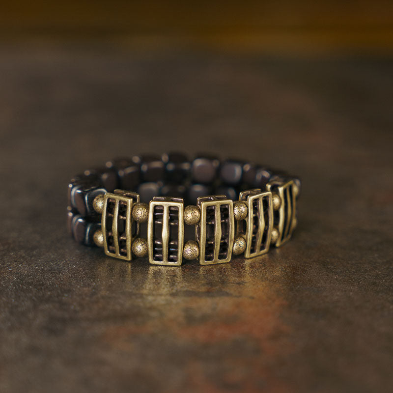 Close-up of the smooth, dark grain of natural Ebony wood slabs on the Serene Lucky architectural bracelet