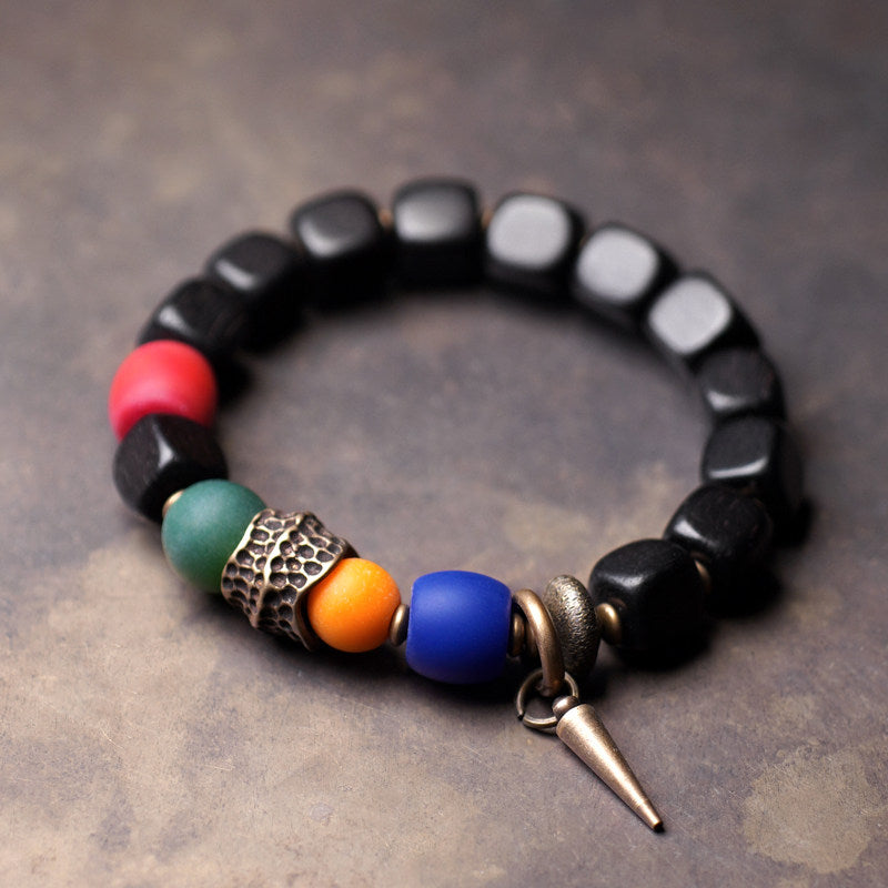 Serene Lucky handcrafted bracelet featuring dark Ebony wood beads, a translucent art glass center, and a vibrant Agate stone.