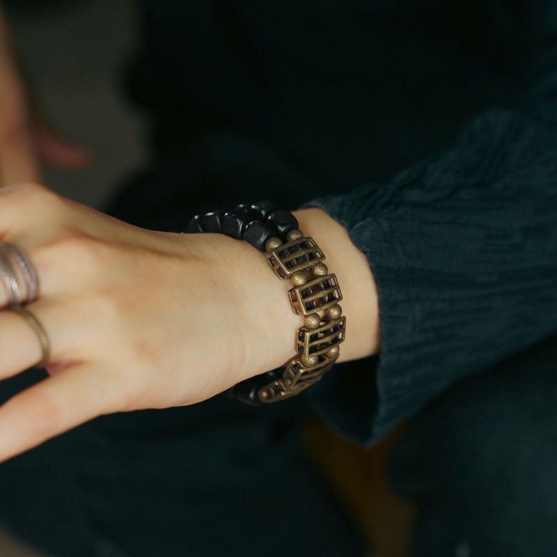 A professional styling shot of the Serene Lucky Ebony and Brass cuff bracelet, highlighting its bold architectural presence on a wrist.