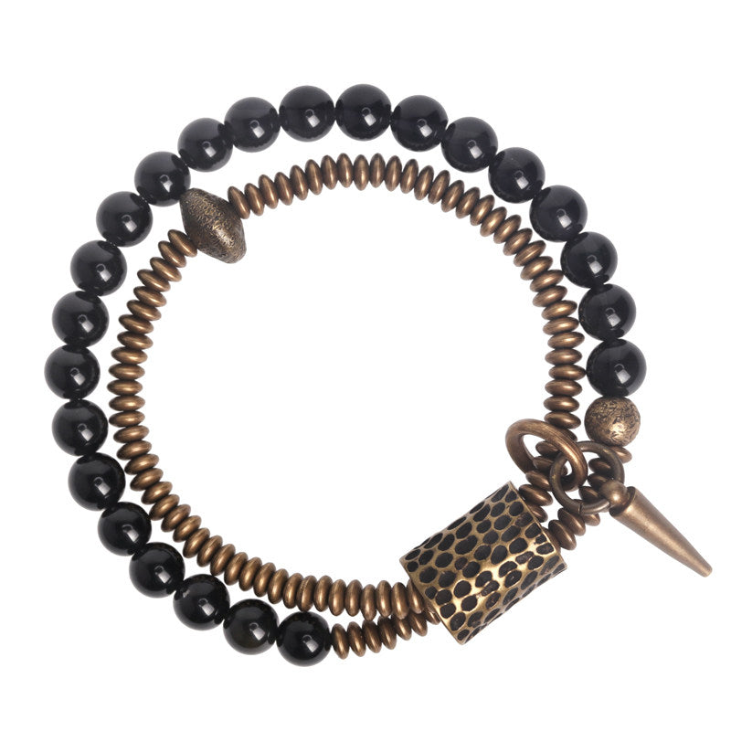 Main product shot of Serene Lucky's Midnight Fortress bracelet, a multi-wrap design with natural black obsidian beads and handcrafted brass hardware on a white background.