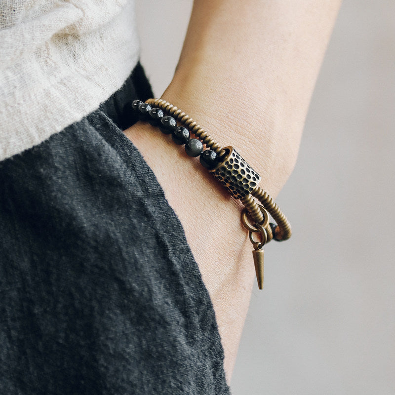 A woman wearing the Serene Lucky Midnight Fortress multi-wrap bracelet styled with denim and a linen cardigan, showcasing its edgy bohemian aesthetic.