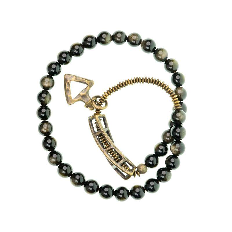 Full view of Serene Lucky's Solar Gears bracelet with golden sheen obsidian and gear-textured brass.